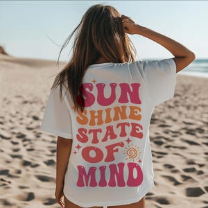 Peut inclure: T-shirt blanc avec un motif rose, orange et jaune qui dit "SUN SHINE STATE OF MIND".