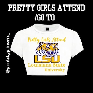 May include: White crop top with the text "Pretty Girls Attend / Go To" at the top. The shirt features a tiger graphic and the text "LSU Louisiana State University" in gold and purple.