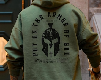 May include: Green hooded sweatshirt with a black graphic print of a warrior's helmet and the text "Put on the Armor of God" with a Bible verse reference.
