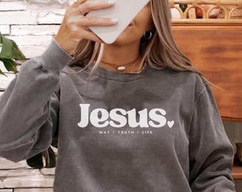 May include: A charcoal gray sweatshirt with a white graphic that says "Jesus. Way, Truth, Life" with a small heart after the word "Life".