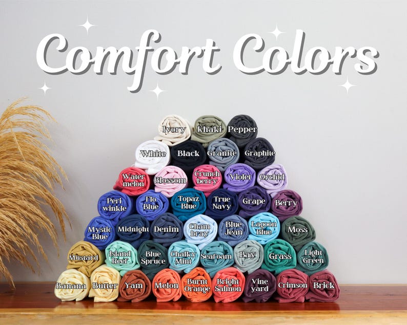 May include: A pyramid of rolled fabric swatches in various colors, including white, black, blue, green, and red. The swatches are labeled with color names, such as "Ivory", "Khaki", "Pepper", "White", "Black", "Granite", "Graphite", "Watermelon", "Blossom", "Crunch Berry", "Violet", "Orchid", "Peri Winkle", "Flo Blue", "Topaz Blue", "True Navy", "Grape", "Berry", "Mystic Blue", "Midnight", "Denim", "Cham Bray", "Blue Jean", "Lagoon Blue", "Moss", "Island Reef", "Blue Spruce", "Chalky Mint", "Seafoam", "Bay Grass", "Light Green", "Banana", "Butter", "Yam", "Melon", "Burnt Orange", "Bright Salmon", "Vine Yard", "Crimson", and "Brick".