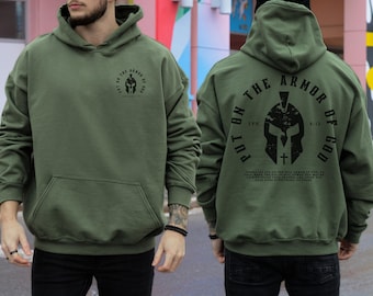 May include: A green hooded sweatshirt with a black graphic print of a helmet and the text "Put on the Armor of God" with a bible verse.