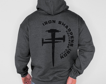 May include: Dark gray hoodie with a black graphic of a cross and the text "IRON SHARPENS IRON PROVERBS 27:17" in a semi-circle above the cross. The hoodie has a hood and long sleeves.