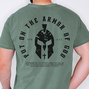May include: Green t-shirt with a black graphic of a helmet and the text "Put on the Armor of God" with the scripture reference "Eph 6:13".