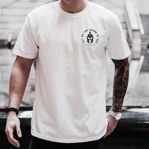 May include: White t-shirt with a black graphic of a helmet and the text "Put on the Armor of God Ephesians 6:11".