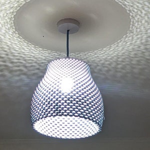 May include: A white ceiling with a white, round, ceiling fixture. A silver, geometric, pendant light fixture hangs from the ceiling fixture. The light is on and illuminates the room.