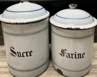 Pode incluir: Conjunto de seis potes vintage de esmalte branco com guarnições azuis e verdes. Os potes têm letras pretas que dizem "Pâtes", "Chicorie", "Thé", "Pois", "Sucre" e "Farine".