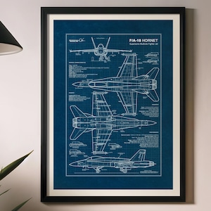 Pode incluir: Planta emoldurada de um caça F/A-18 Hornet. A impressão apresenta desenhos técnicos detalhados em branco sobre um fundo de grade azul escuro. O texto "F/A-18 HORNET" é visível no topo. A impressão está em uma moldura preta.