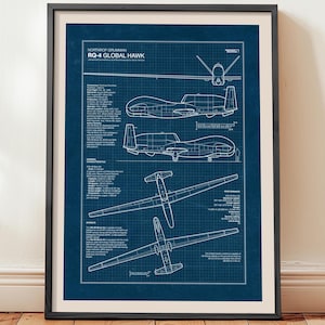 May include: Framed blueprint art print of the Northrop Grumman RQ-4 Global Hawk. The print features detailed technical drawings of the unmanned aerial vehicle (UAV) in white against a dark blue background. The print is in a black frame.