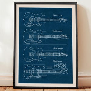 Puede incluir: Impresión enmarcada con dibujos lineales blancos de cuatro diseños de guitarras Fender: Stratocaster, Telecaster, Telecaster y Jazz Bass. Los diseños están sobre un fondo azul oscuro. La impresión está en un marco negro y se muestra en una pared.