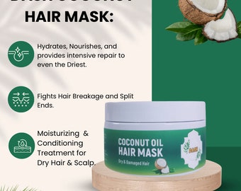 May include: White jar with a green label that reads "Coconut Oil Hair Mask" and "Dry & Damaged Hair". The jar is sitting on a wooden surface. The jar is surrounded by green leaves and a coconut.