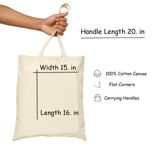 May include: A beige tote bag with black handles and black text that reads "Handle Length 20. in", "Width 15. in", and "Length 16. in". The bag is made of 100% cotton canvas and has flat corners. It also has carrying handles.