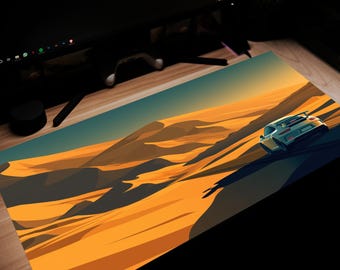 May include: A rectangular desk mat featuring a stylized desert landscape with a sports car driving on a dune. The mat has a teal and orange color scheme, with the car in shades of white and gray.