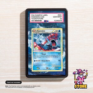 May include: A Pokemon card encased in a black display case. The card features a Gyarados illustration with the text "Gyarados 130". The case has a PSA example label with the text "GEM MINT 10". The TCG Store logo is in the bottom right corner.