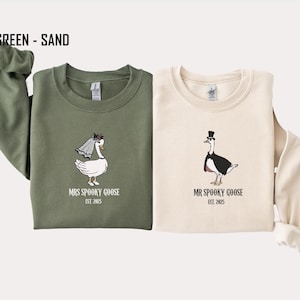 Our "MR & MRS SILLY GOOSE" matching sweatshirts are the perfect way to celebrate love with a side of humor. Featuring hand-drawn, adorable geese (complete with veil and all!) and the cute title “Silly Goose,” these cozy sweaters are sure to bring smiles wherever you go.