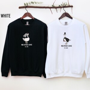 Our "MR & MRS SILLY GOOSE" matching sweatshirts are the perfect way to celebrate love with a side of humor. Featuring hand-drawn, adorable geese (complete with veil and all!) and the cute title “Silly Goose,” these cozy sweaters are sure to bring smiles wherever you go.