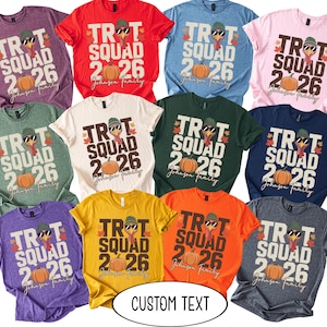 May include: A collection of eleven short-sleeved t-shirts in various colors, each featuring a graphic of a turkey wearing a beanie and sunglasses, with the text TROT SQUAD 2026 and Johnson family, accompanied by a pumpkin and autumn leaves.