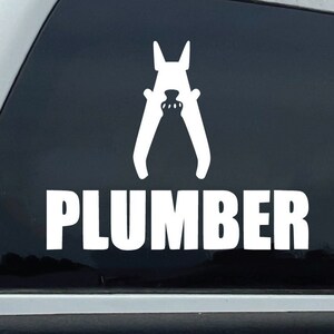 Puede incluir: Camioneta blanca con una pegatina de ventana negra que dice "PLUMBER" con una silueta de un par de alicates.