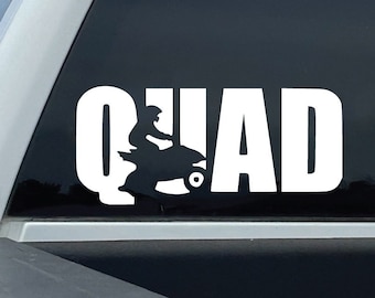 Może przedstawiać: Biała naklejka winylowa z napisem "QUAD" i sylwetką osoby jadącej na quadzie. Naklejka znajduje się na tylnej szybie białego pickupa.