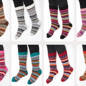 May include: Eight pairs of knee-high socks, each with a different pattern and colour combination. Designs include geometric and traditional motifs in various colours such as brown, blue, pink, and red. The socks are displayed on legs.