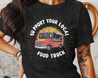 Peut inclure: Un t-shirt noir avec un graphique d'un camion de nourriture jaune et le texte "Support Your Local Food Truck".