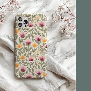 May include: A phone case with a floral pattern featuring pink, yellow, and green flowers on a cream background.