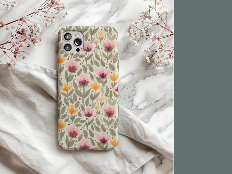 May include: A phone case with a floral pattern featuring pink, yellow, and green flowers on a cream background.