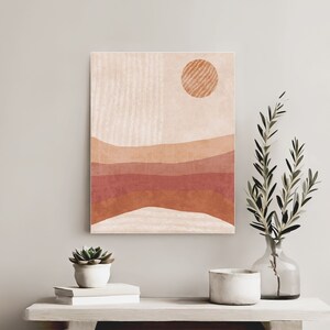 Puede incluir: Impresi&oacute;n de arte abstracto con un dise&ntilde;o minimalista que presenta un sol y l&iacute;neas onduladas superpuestas en tonos de naranja, rojo y marr&oacute;n sobre un fondo crema.