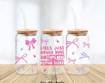 Peut inclure: Trois verres à boire en verre transparent avec des couvercles en bambou et des nœuds roses et bleus. Chaque verre à boire a une paille et le verre du milieu a le texte "Girls just wanna have fundamental human rights" imprimé dessus.