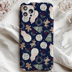 May include: A blue phone case with a winter holiday theme. The case features a repeating pattern of snowmen, reindeer, gingerbread men, and Christmas trees. The pattern is on a dark blue background.