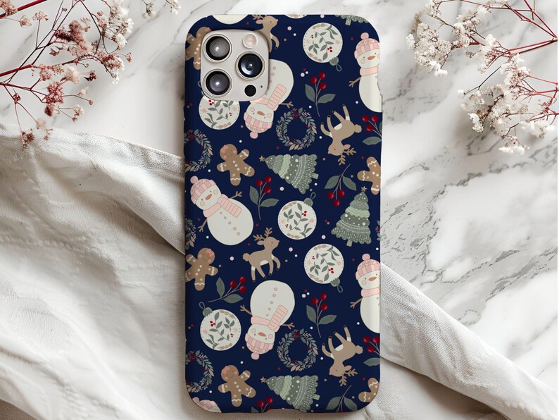 May include: A blue phone case with a winter holiday theme. The case features a repeating pattern of snowmen, reindeer, gingerbread men, and Christmas trees. The pattern is on a dark blue background.