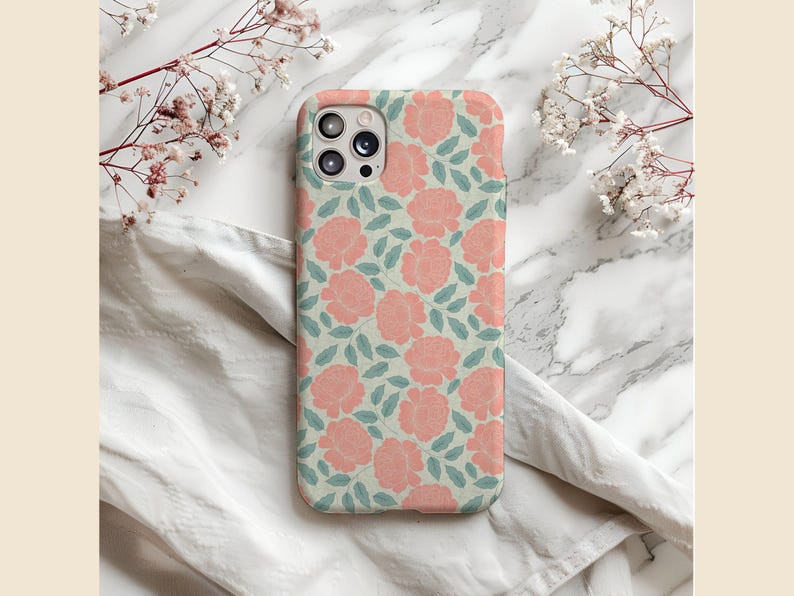 May include: A white phone case with a pink floral pattern. The case has a camera lens cutout and a raised lip around the edges.