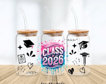 Peut inclure: Trois gobelets en verre transparents avec des couvercles en bambou et des pailles en verre. Le gobelet central affiche "CLASS OF 2026" en rose et bleu. Les autres gobelets présentent des graphiques noirs sur le thème de la remise de diplômes.