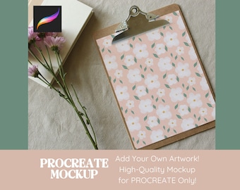 Peut inclure: Un presse-papiers avec un motif floral de fleurs blanches et de feuilles vertes sur fond rose. À côté, des papiers blancs, une icône de l'application Procreate et des fleurs roses. Le texte indique "PROCREATE MOCKUP".