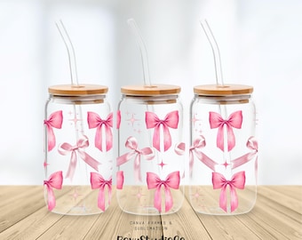 Peut inclure: Trois verres à boire en verre transparent avec des nœuds roses et des motifs de paillettes. Chaque verre à boire a un couvercle en bambou et une paille en plastique transparente.