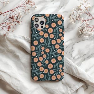 May include: A dark blue phone case with a floral pattern featuring pink flowers and green leaves.