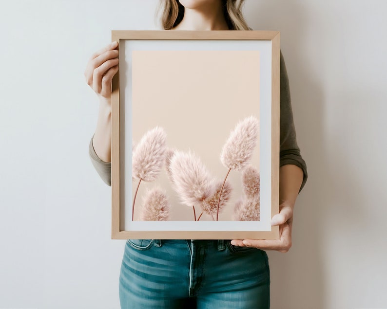 Puede incluir: Una impresi&oacute;n enmarcada de una fotograf&iacute;a que presenta un grupo de flores secas suaves de color rosa p&aacute;lido sobre un fondo beige claro.