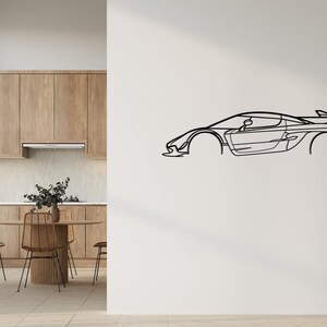 Puede incluir: Un dibujo lineal negro de un coche deportivo montado en una pared blanca. El coche presenta un dise&ntilde;o elegante y aerodin&aacute;mico con un aler&oacute;n. La obra de arte es una representaci&oacute;n minimalista de un veh&iacute;culo de alto rendimiento.