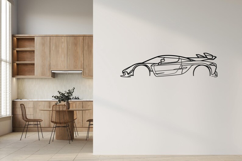 Puede incluir: Un dibujo lineal negro de un coche deportivo montado en una pared blanca. El coche presenta un dise&ntilde;o elegante y aerodin&aacute;mico con un aler&oacute;n. La obra de arte es una representaci&oacute;n minimalista de un veh&iacute;culo de alto rendimiento.