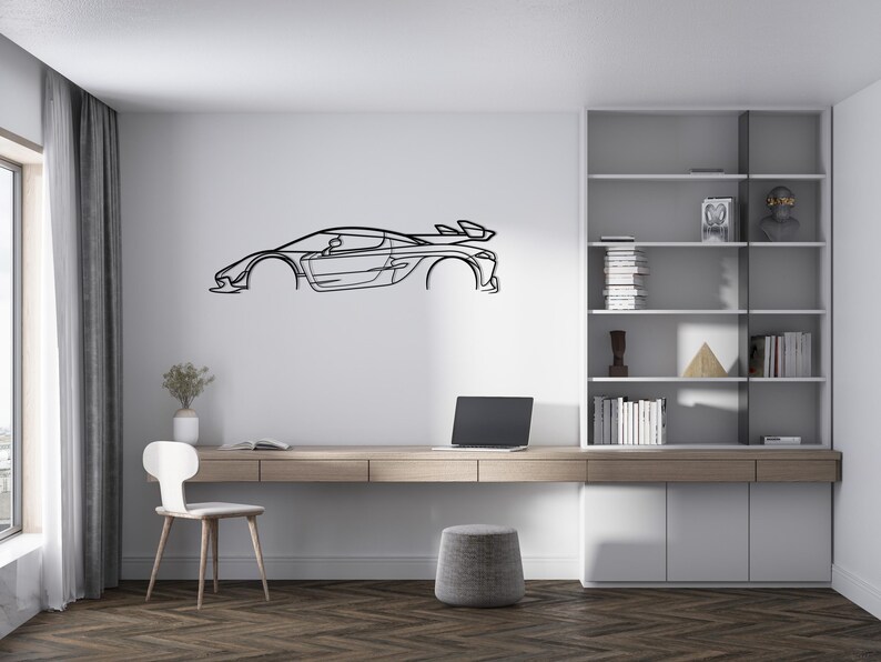 Puede incluir: Arte de pared de metal negro con el contorno de un coche deportivo, montado en una pared blanca. El coche tiene un aler&oacute;n y un dise&ntilde;o aerodin&aacute;mico. La habitaci&oacute;n incluye un escritorio, una silla y una estanter&iacute;a.