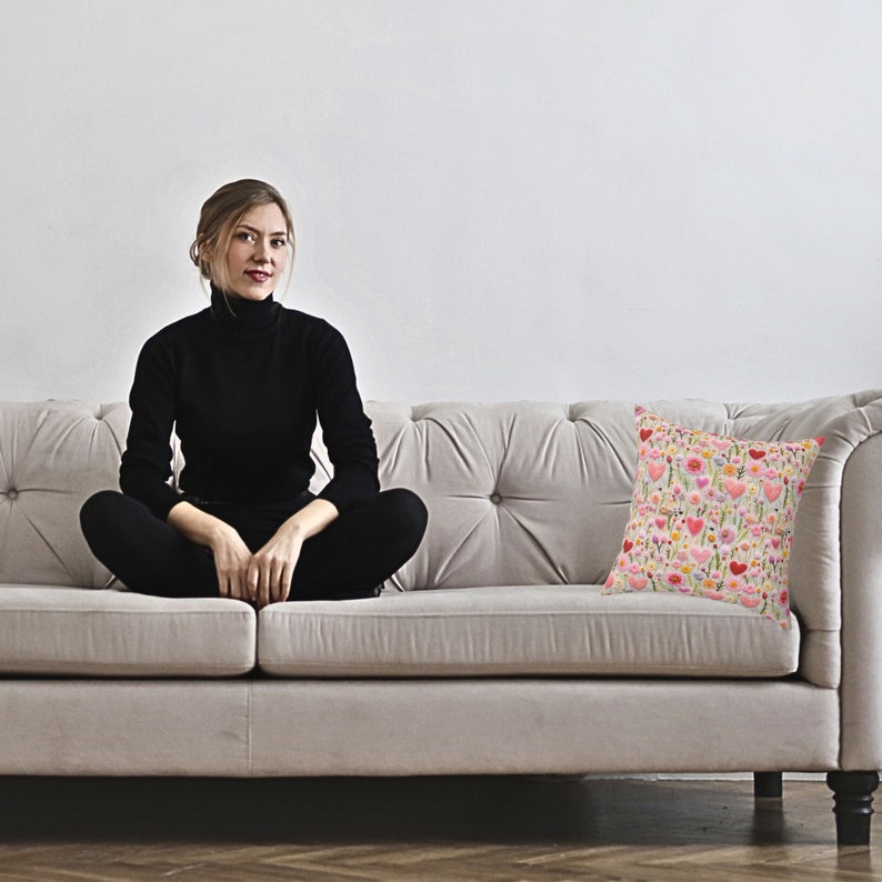 woman on sofa with pillow with design of hearts and flowers
