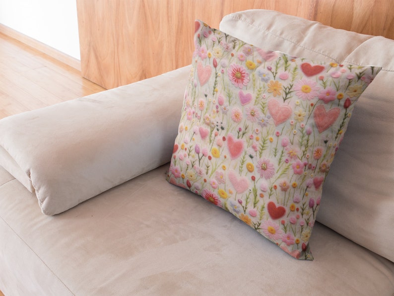 May include: A white throw pillow with a floral pattern featuring pink hearts and flowers on a light green background.