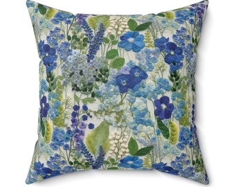 May include: A decorative cushion with a floral pattern featuring blue and green flowers on a white background.