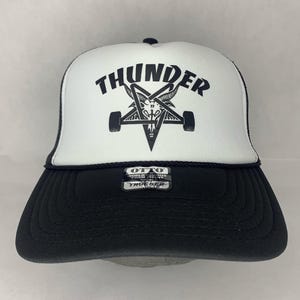 May include: A white ceramic mug with a black handle and the text "But First, Coffee" in a black, bold font. The mug is on a white surface.