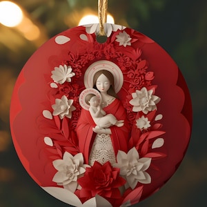 May include: Red and white Christmas ornament featuring a paper-cut design of Mary and baby Jesus surrounded by flowers.