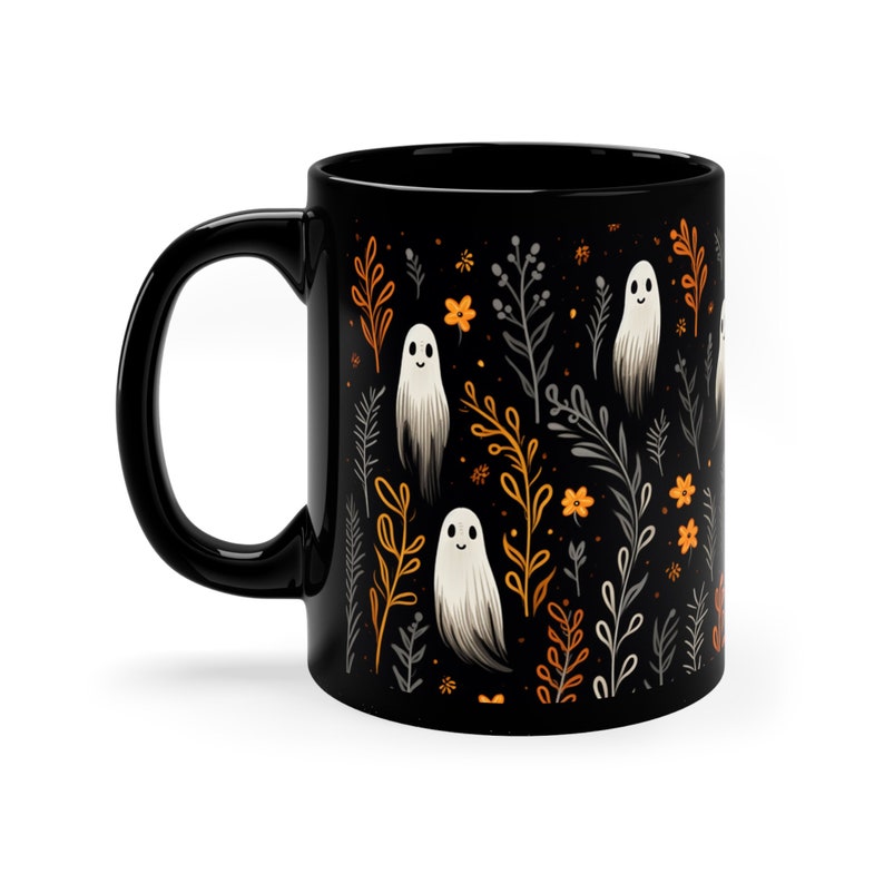 Black ceramic coffee mug featuring a whimsical Halloween design with cute white ghosts surrounded by orange, yellow, and gray autumn foliage and flowers on a dark background. The mug has a glossy finish and a large handle for comfortable use. Available in 11 oz or 15 oz sizes, this festive fall mug is both microwave safe and dishwasher safe, making it a practical yet fun seasonal drinkware choice for coffee, tea, or hot cocoa. (11 oz shown)