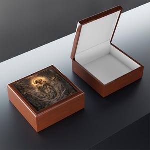 May include: Two wooden keepsake boxes. One box is open, revealing a white interior. The other box is closed. Both boxes have a dark brown finish and a detailed relief image on the lid. The relief depicts a religious scene with figures and a halo.