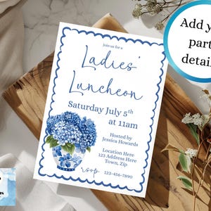 Może przedstawiać: Białe zaproszenie z niebieską, falistą obwódką, z tekstem "Ladies' Luncheon" i szczegółami wydarzenia 5 lipca. Dołączona jest niebiesko-biała ilustracja kwiatowa. Zaproszenie leży na drewnianej powierzchni.