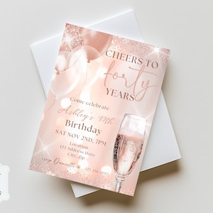 Op de afbeelding: Een roze gouden uitnodigingskaart met de tekst "Cheers to Forty Years" en "Ashley's 40th Birthday". De kaart toont een champagneglas, ballonnen en evenementdetails. De uitnodiging ligt op een witte envelop.