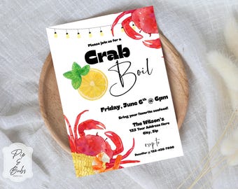 Puede incluir: Una invitación en acuarela para un "Crab Boil", con cangrejos rojos, una rodaja de limón y hojas de menta. La invitación incluye el texto "Crab Boil", la fecha, la hora y la información de RSVP. La invitación está sobre un plato de madera.